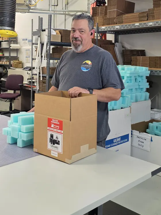 An Applied Science team member packing a HemoFlow device for shipment in Grass Valley, California